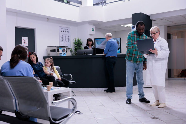 Medical professional consulting with a patient in a modern healthcare setting, showcasing digital engagement and patient care.