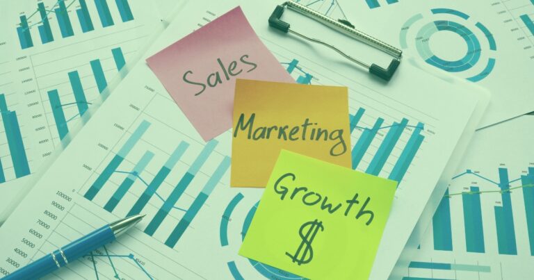 Sales, Marketing, Growth sticky notes on financial charts, illustrating digital marketing strategies and ROI optimisation.